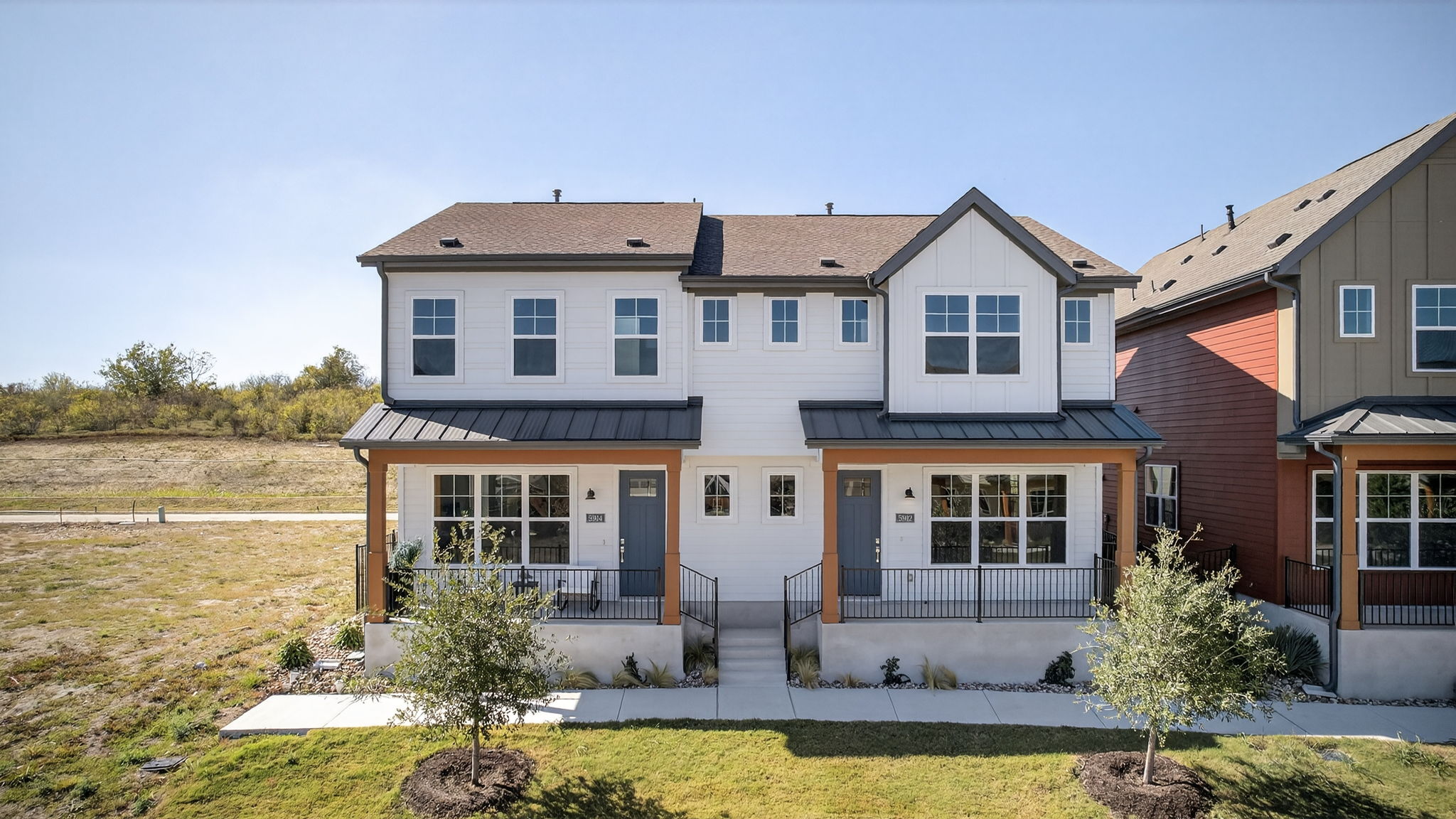 Modern farmhouse with a standing seam roof, board and batten siding, and a front yard