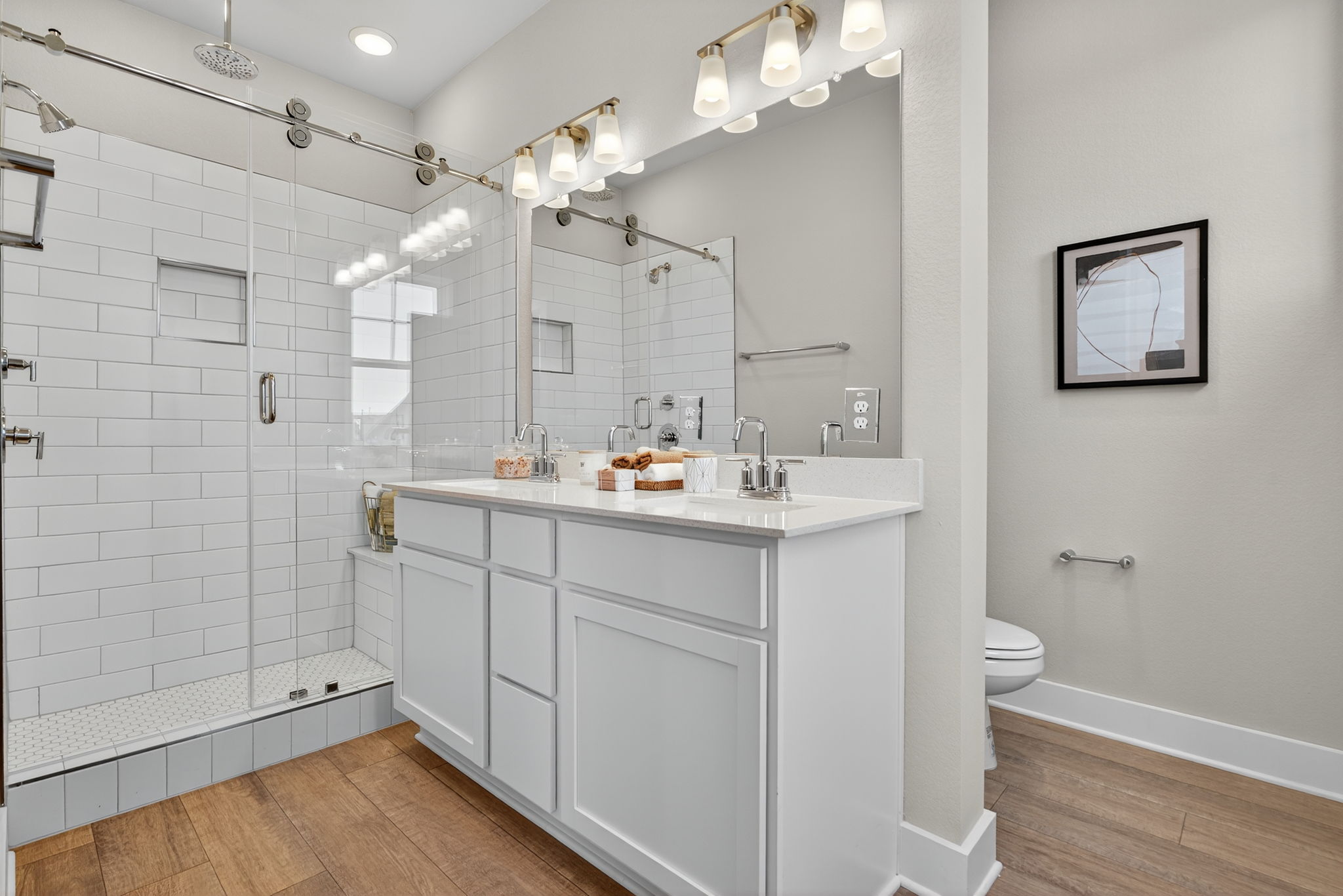 5902 Rotunda View Austin, TX 78747 - Photo 25 of 38 Full bathroom with double vanity, light wood-type flooring, and a shower stall