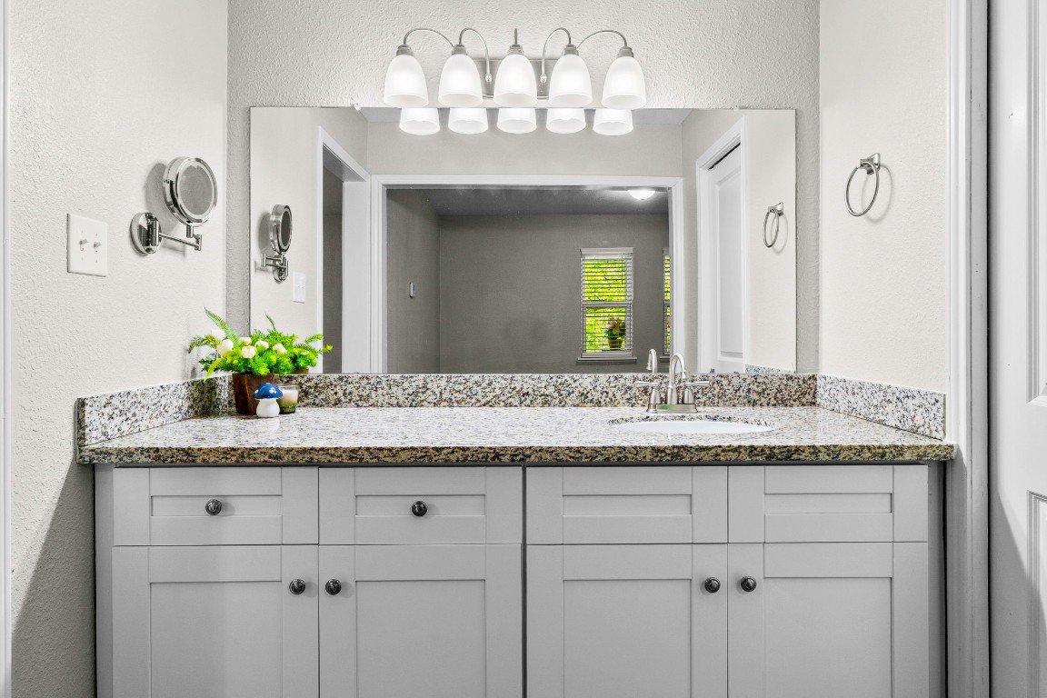 21 Red Oak Circle Point Blank, TX 77364 - Photo 18 of 50 a bathroom with a granite countertop sink and a mirror
