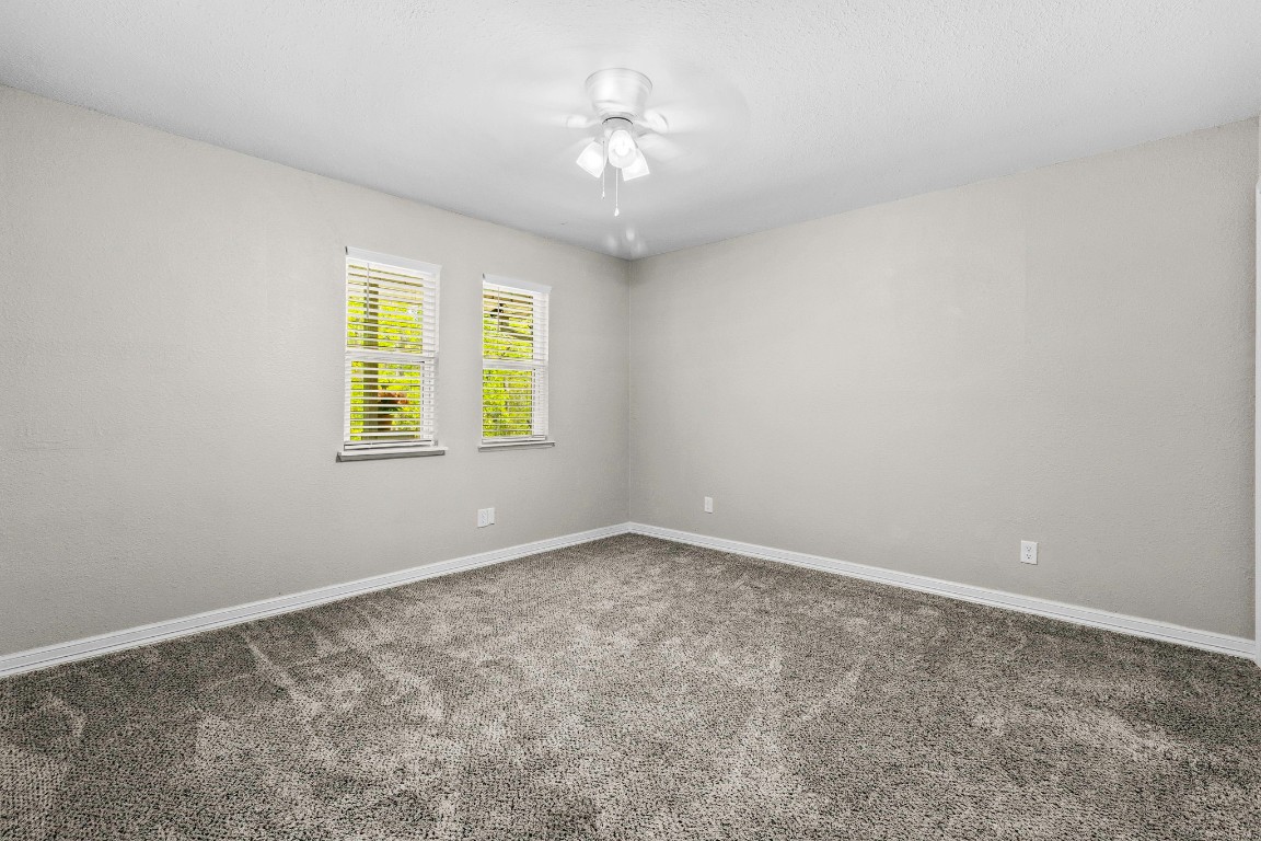 21 Red Oak Circle Point Blank, TX 77364 - Photo 19 of 50 an empty room with windows and chandelier fan