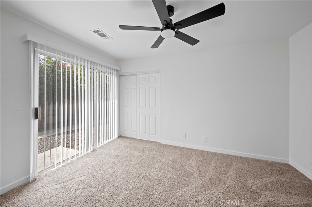 22 Oak Tree Drive Rancho Mirage, CA 92270 - Photo 9 of 25 an empty room with a ceiling fan and window