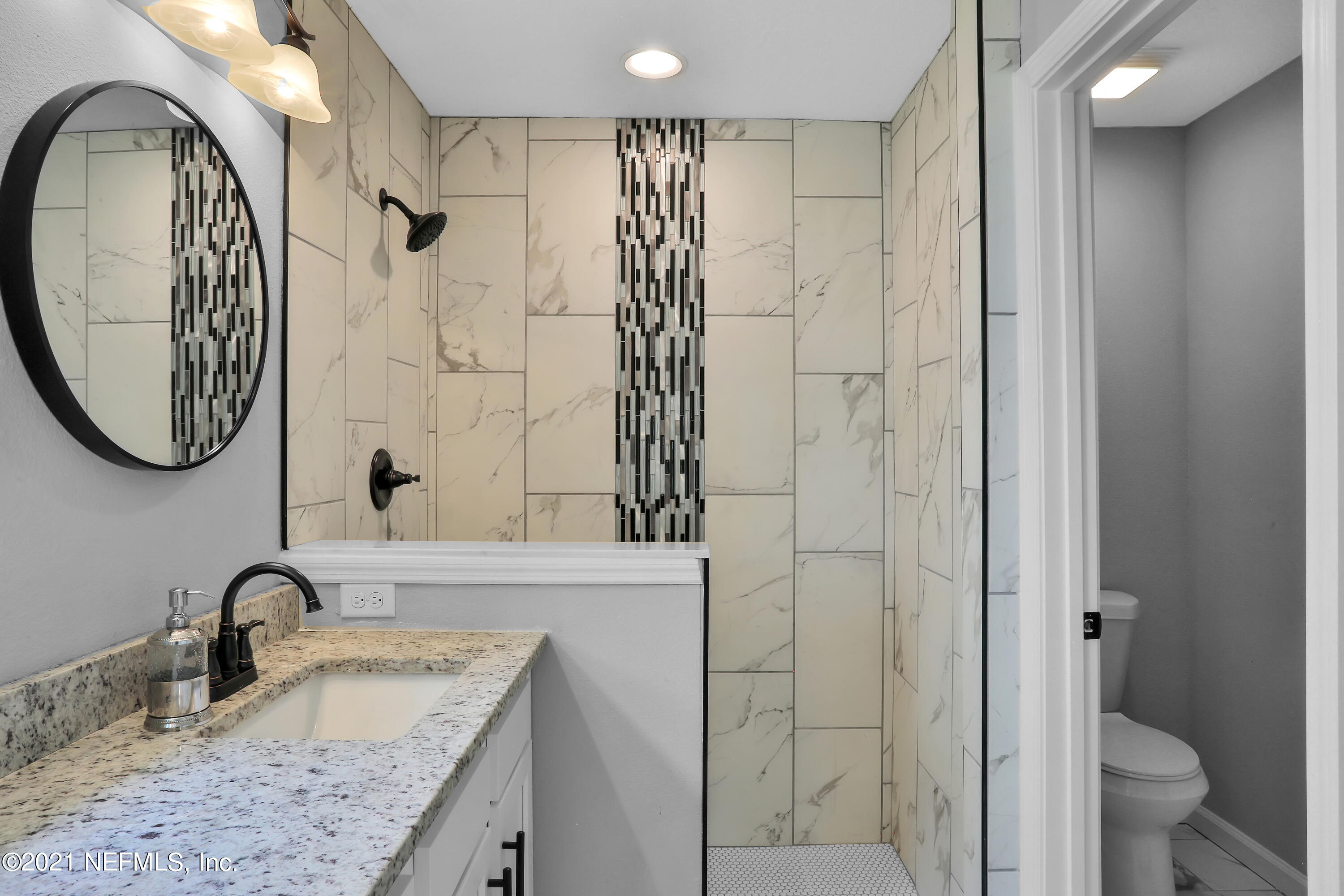 6442 Heidi Road Jacksonville, FL 32277 - Photo 16 of 30 a bathroom with a granite countertop sink a toilet and shower
