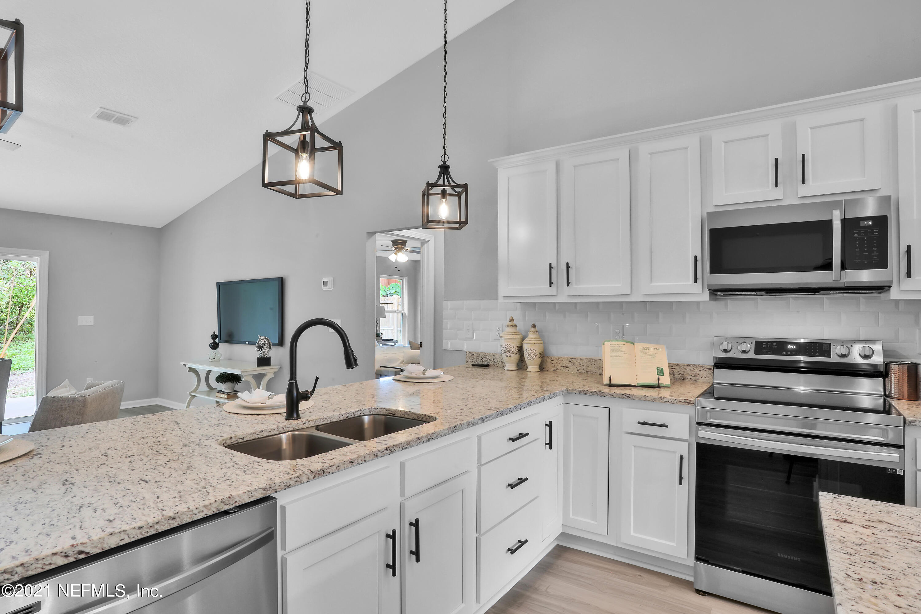 6442 Heidi Road Jacksonville, FL 32277 - Photo 5 of 30 a kitchen with stainless steel appliances granite countertop a sink a stove and a microwave oven