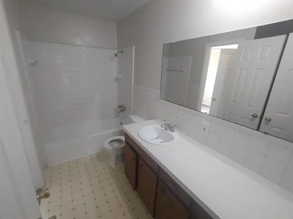 a bathroom with a double vanity sink a toilet and a mirror