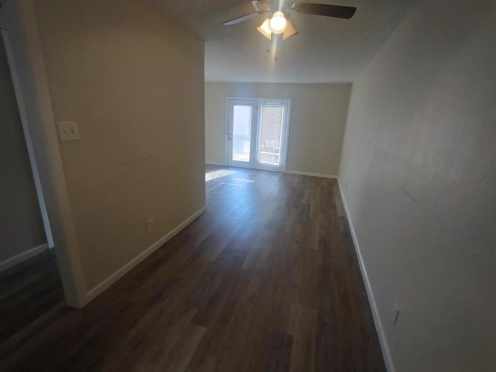 7816 Romney Road, Unit 3 Fort Worth, TX 76134 - Photo 5 of 18 a view of a hallway with wooden floor and a chandelier