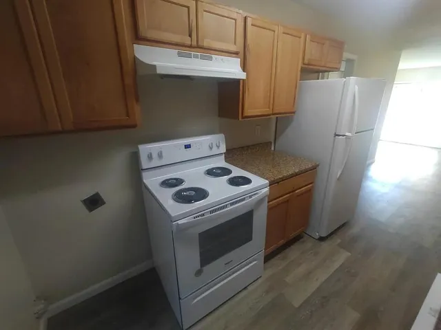 a kitchen with a stove top oven and refrigerator
