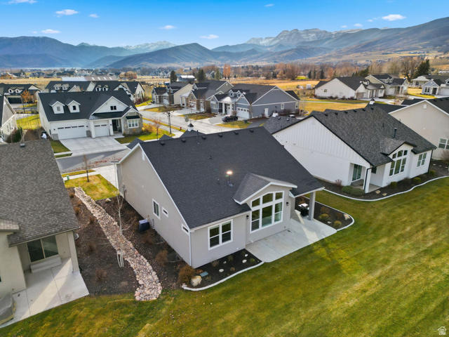 108 West Monte Rosa Lane Midway, UT 84049 - Photo 43 of 48 Rear exterior featuring a covered patio, extensive lawn, and large windows