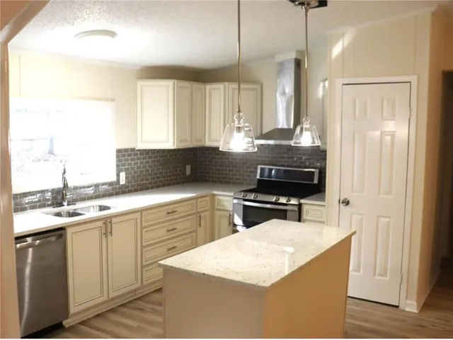 a kitchen with granite countertop a stove sink and cabinets