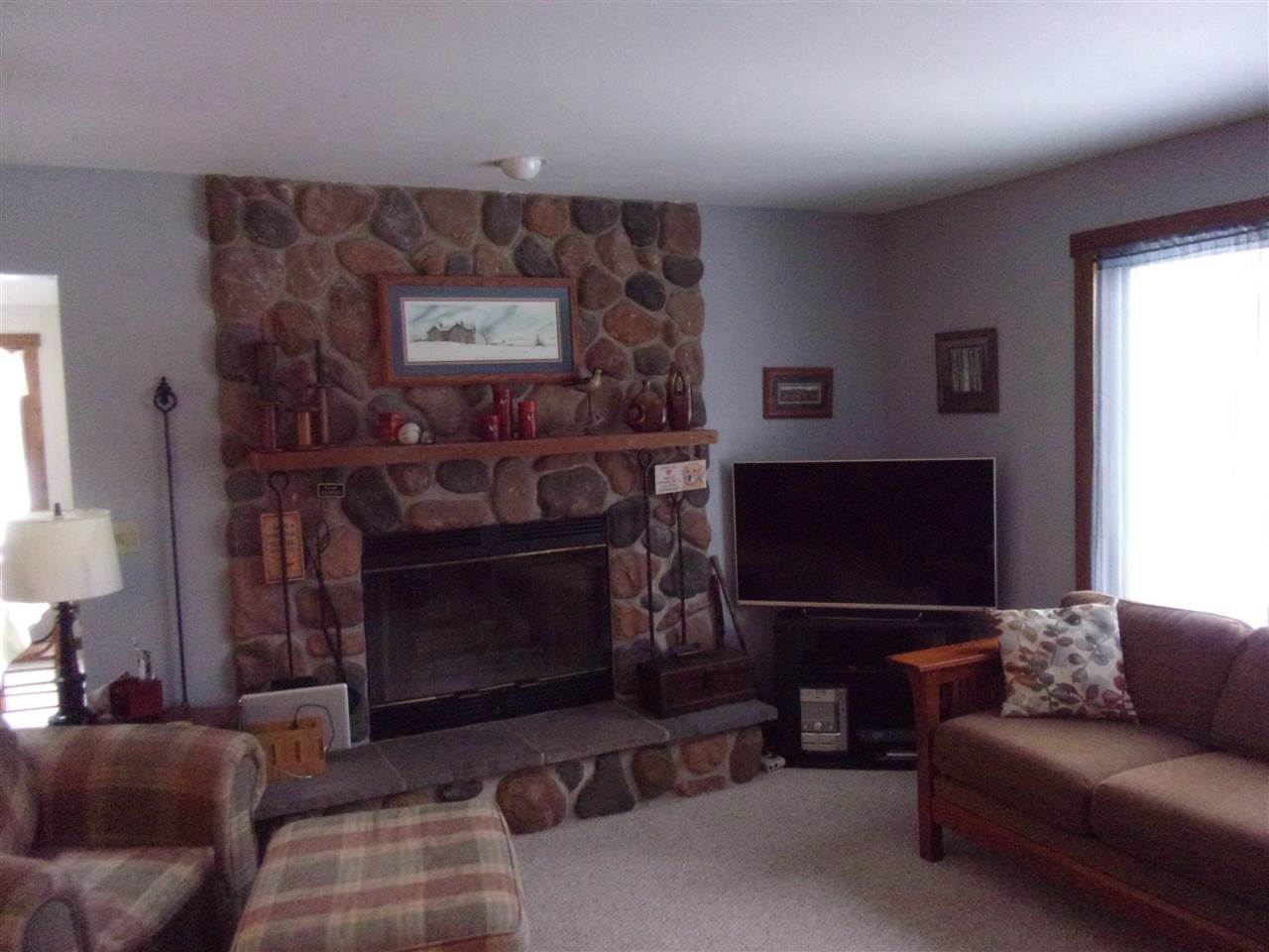 3745 Freeport Road Rockton, IL 61072 - Photo 11 of 24 a living room with furniture a flat screen tv and a fireplace