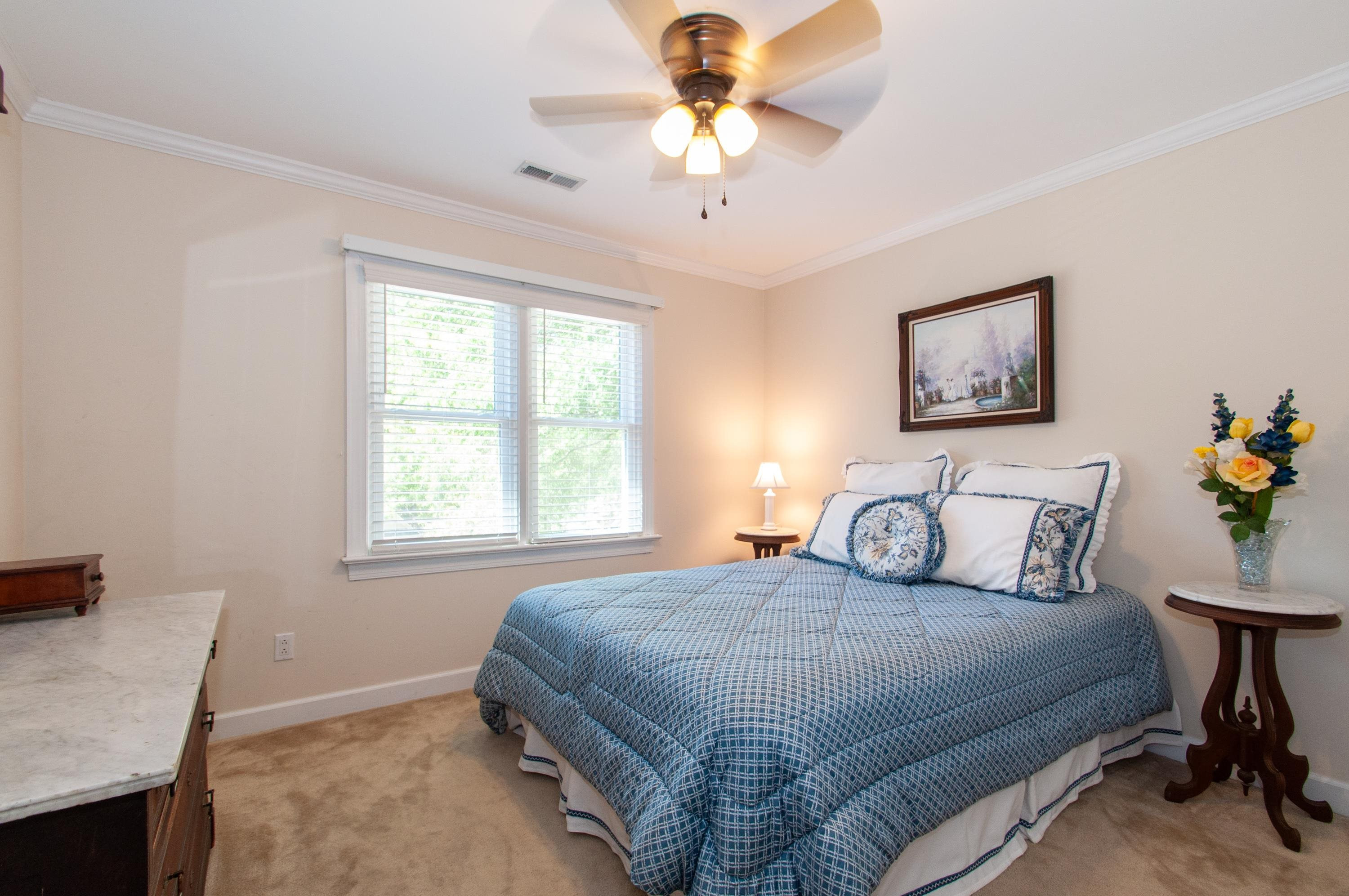 7914 Footman Way Raleigh, NC 27615 - Photo 18 of 38 a bedroom with a bed and a chandelier