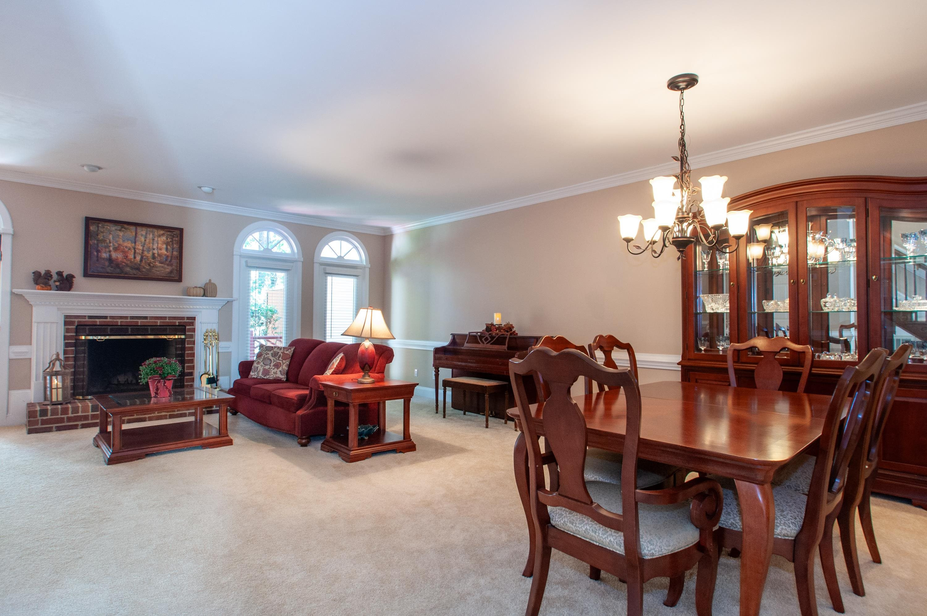 7914 Footman Way Raleigh, NC 27615 - Photo 3 of 38 a dining room with furniture chandelier and a fireplace