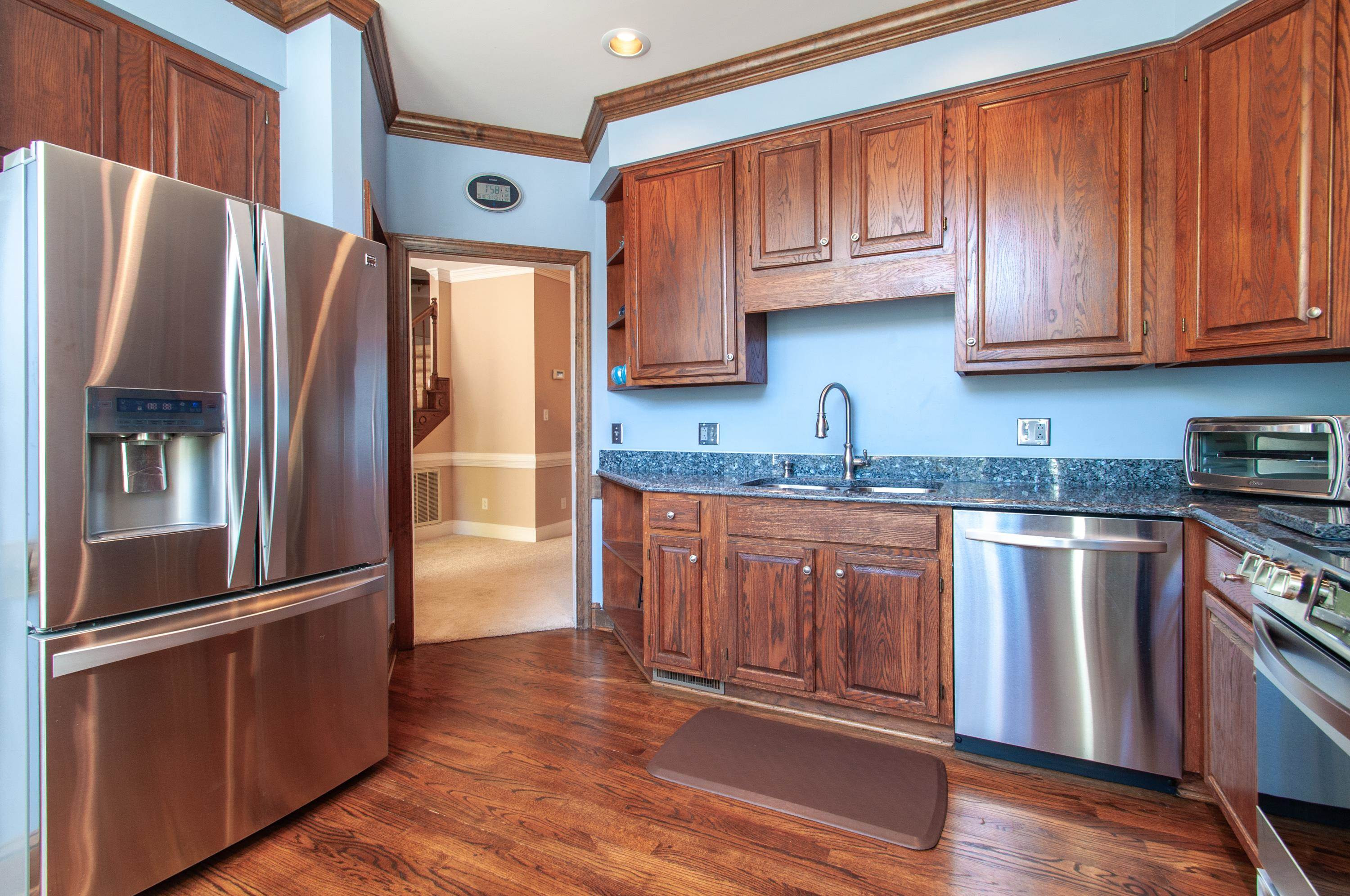7914 Footman Way Raleigh, NC 27615 - Photo 10 of 38 a kitchen with stainless steel appliances granite countertop a refrigerator stove a sink and dishwasher with wooden floor