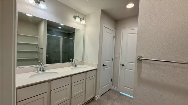 a bathroom with a double vanity sink mirror and shower