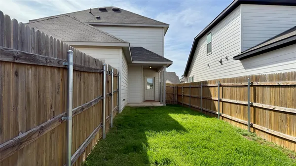 a view of a backyard with wooden fence and a stairs