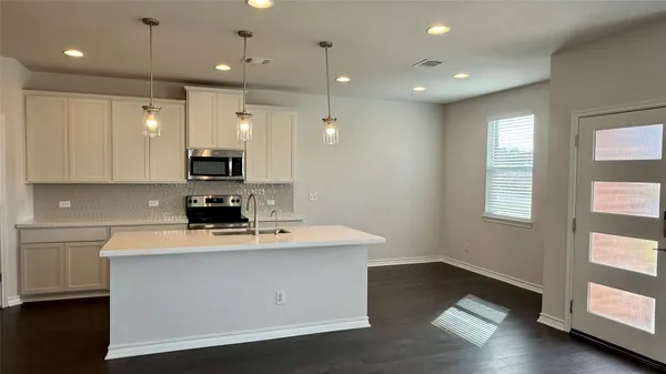 a kitchen with kitchen island white cabinets and window