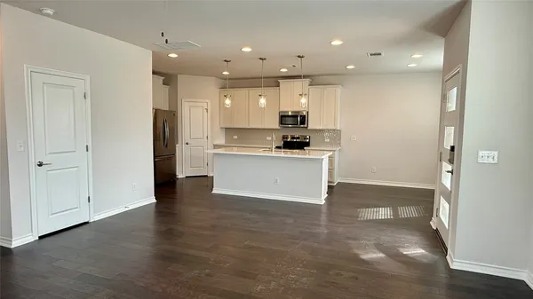 a view of kitchen with kitchen island stainless steel appliances a stove a refrigerator and cabinets
