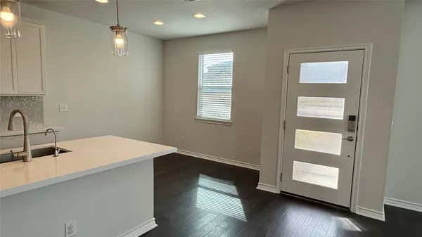 a room with wooden floor and windows