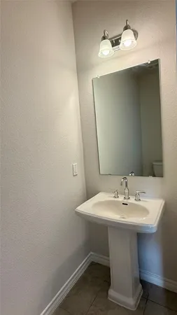 a white sink sitting under a bathroom mirror