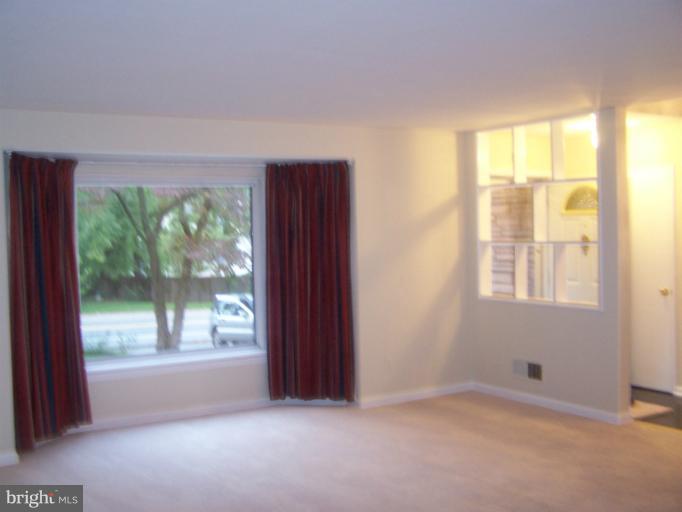6002 Greentree Road Bethesda, MD 20817 - Photo 6 of 14 a view of an empty room with wooden floor and a window