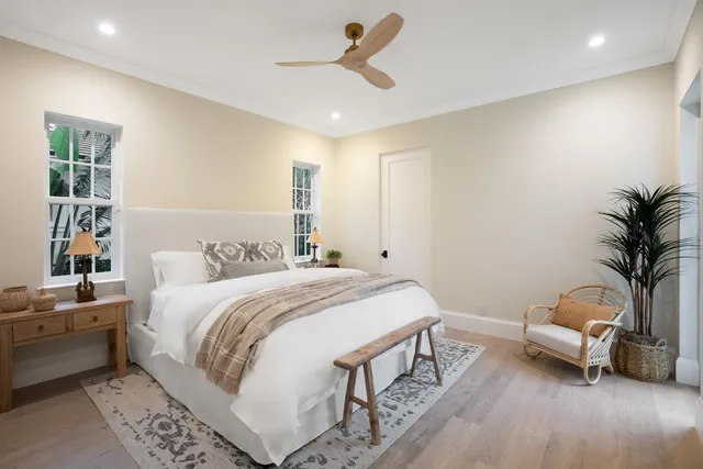 a spacious bedroom with a bed and ceiling fan