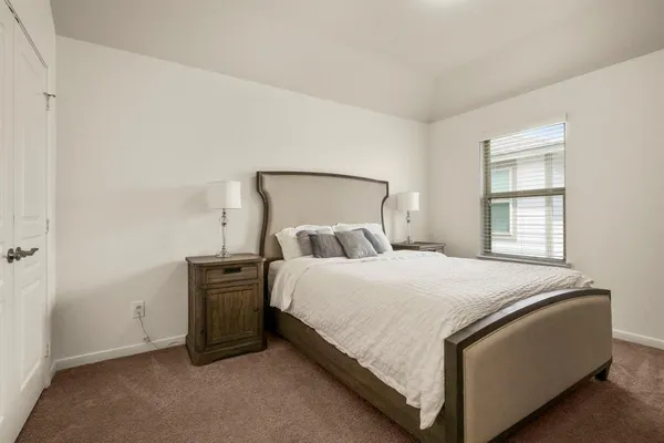 a bed sitting in a bedroom next to a window and dresser
