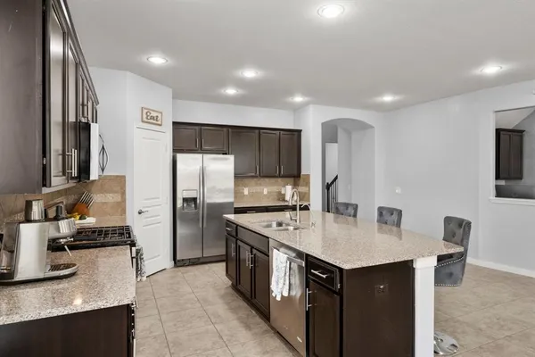 a kitchen with stainless steel appliances granite countertop a sink stove and refrigerator