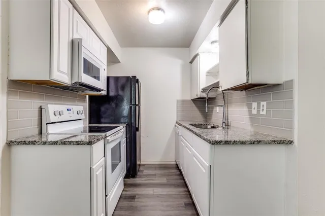 a kitchen with granite countertop cabinets stainless steel appliances and a counter space