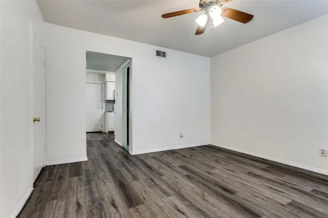 wooden floor in an empty room with a chandelier