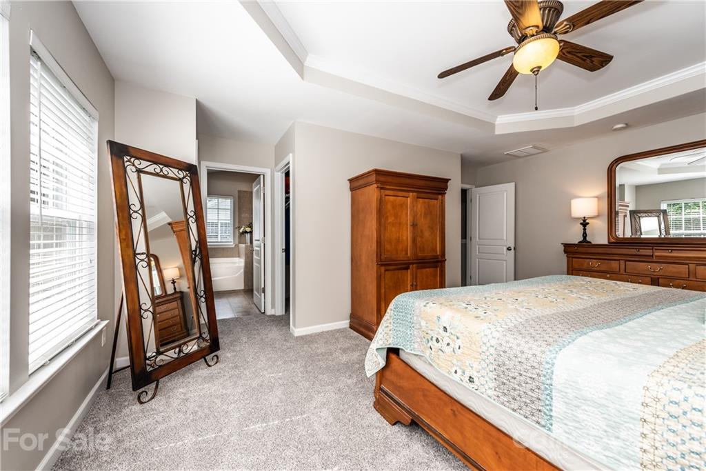 151 Whitley Mills Road Fort Mill, SC 29708 - Photo 19 of 33 a spacious bedroom with a bed and a chandelier