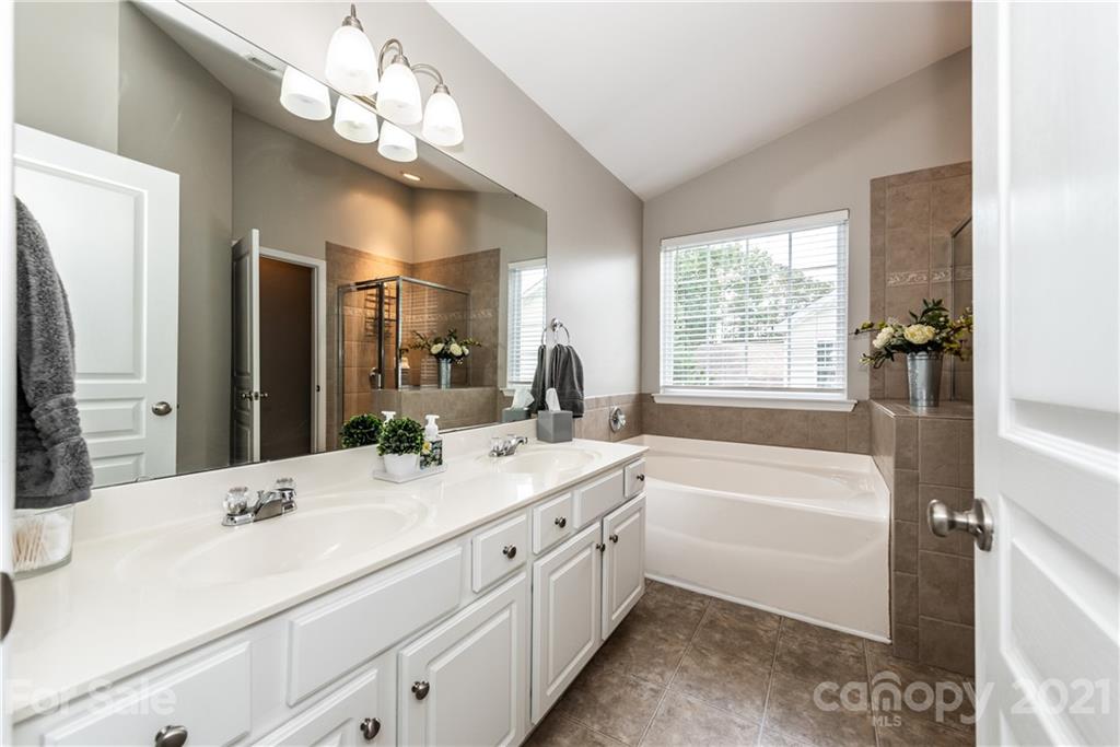 151 Whitley Mills Road Fort Mill, SC 29708 - Photo 20 of 33 a bathroom with a double vanity sink a large mirror a bathtub and a shower