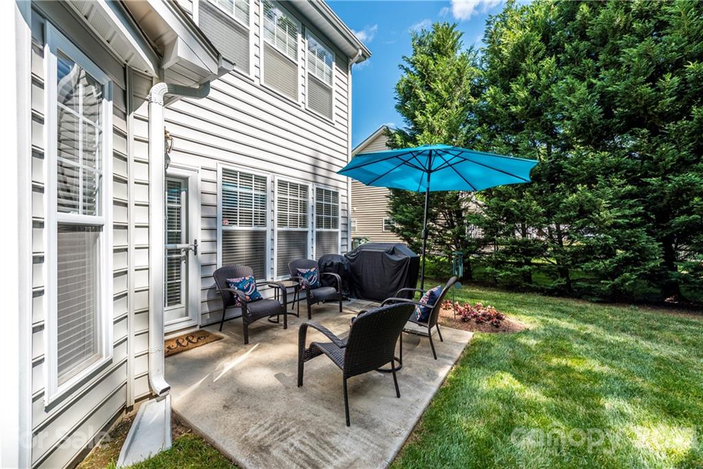 151 Whitley Mills Road Fort Mill, SC 29708 - Photo 28 of 33 a view of a patio with couches table and chairs under an umbrella