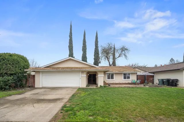 a aerial view of a house with a yard and trees
