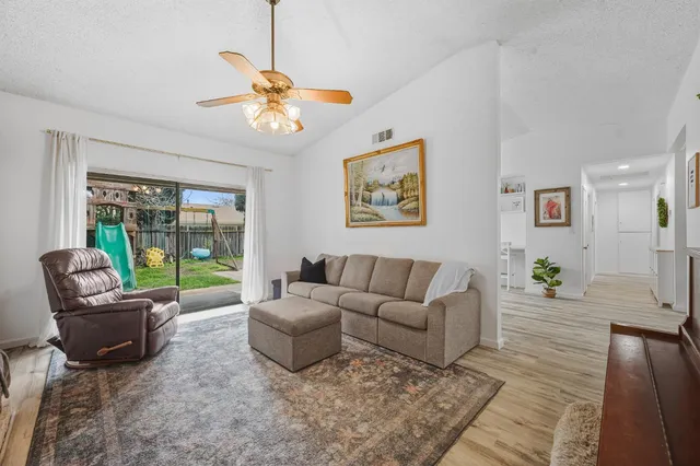 a living room with furniture a chandelier and a floor to ceiling window