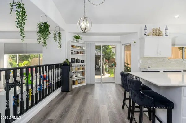 a view of a dining room and livingroom with furniture wooden floor a chandelier