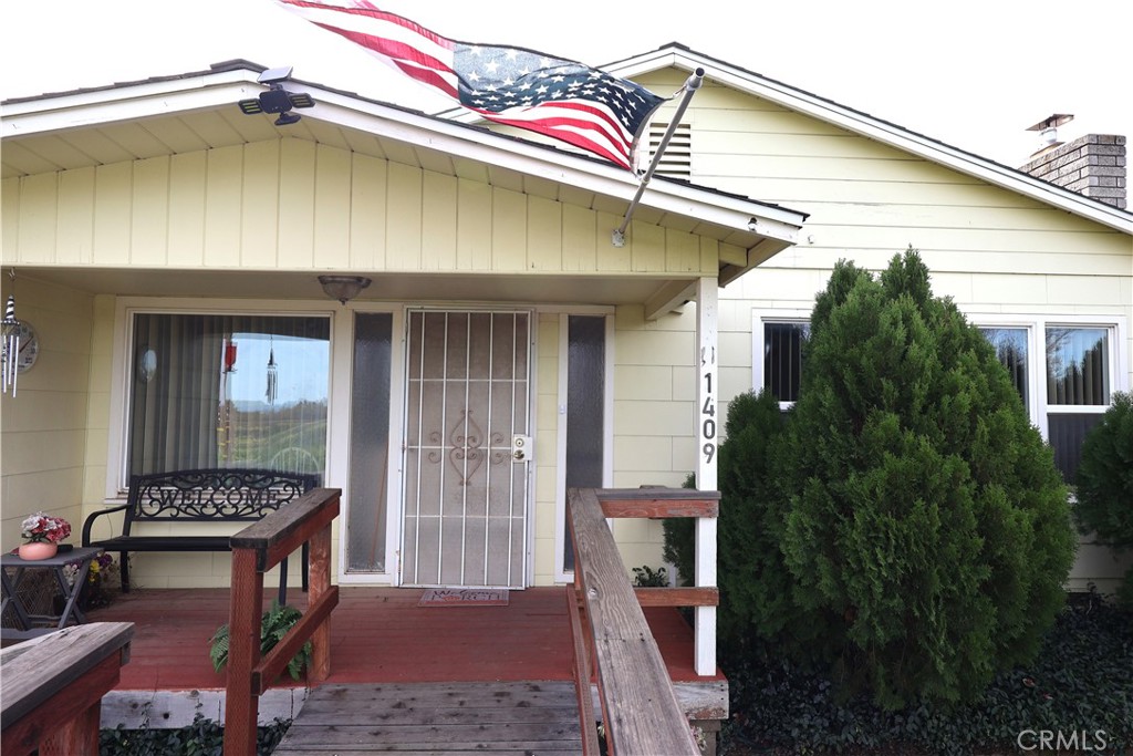 1409 North Street Corning, CA 96021 - Photo 3 of 40 a yellow house with table and chairs in front of it
