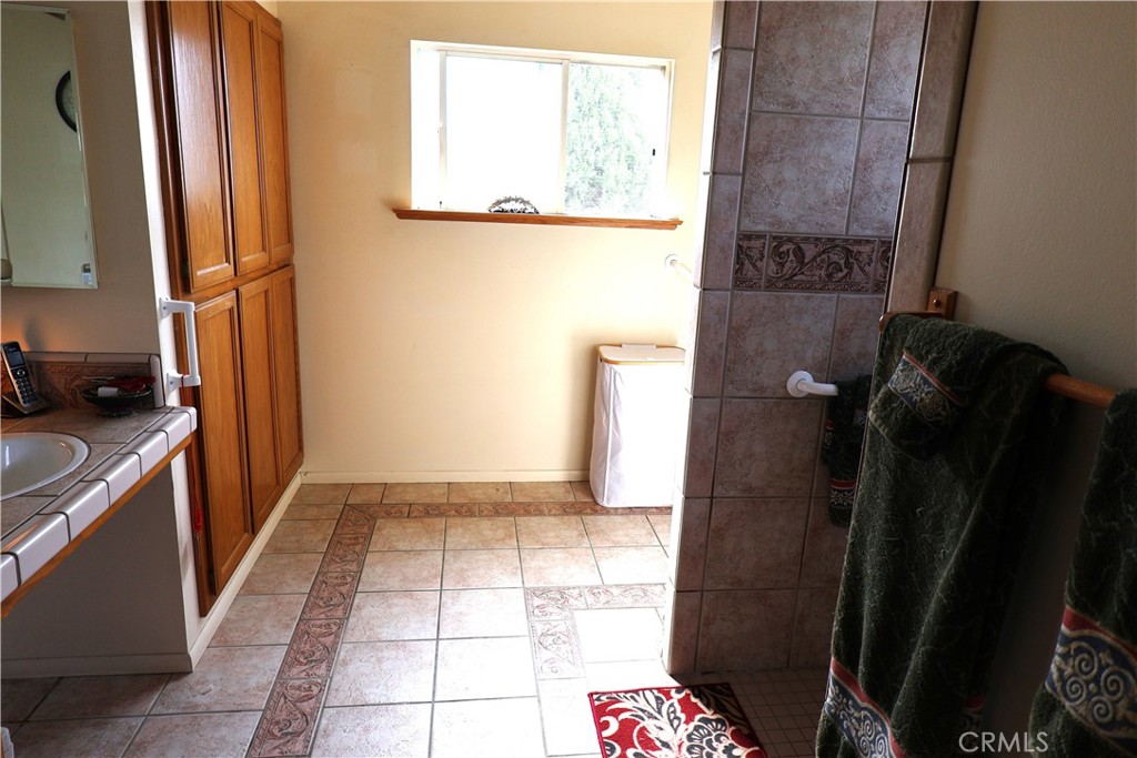1409 North Street Corning, CA 96021 - Photo 36 of 40 a bathroom with a granite countertop shower a sink and a stove