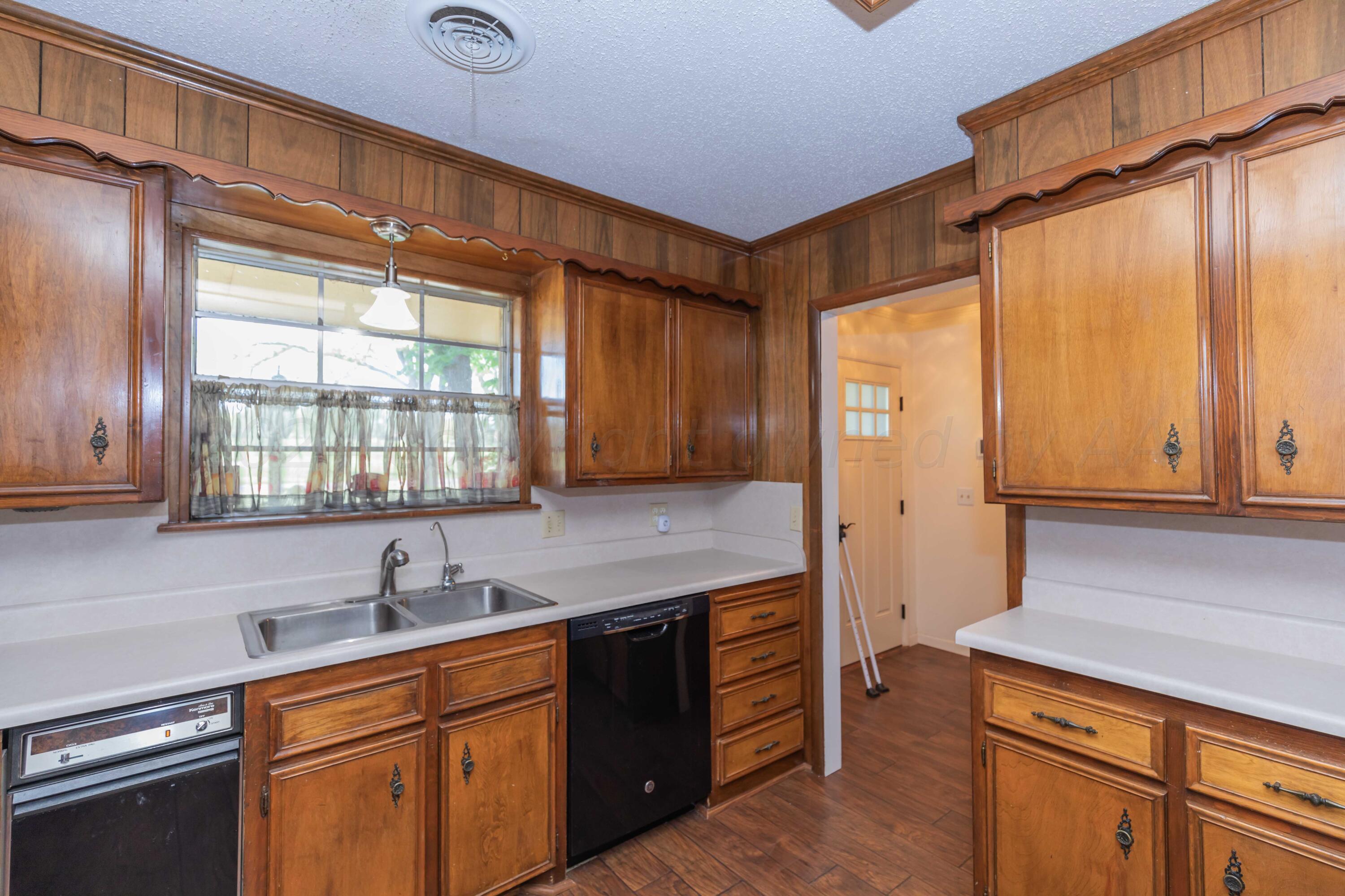 4400 Gem Lake Road Amarillo, TX 79106 - Photo 11 of 57 a kitchen with stainless steel appliances granite countertop wooden cabinets a sink and a window