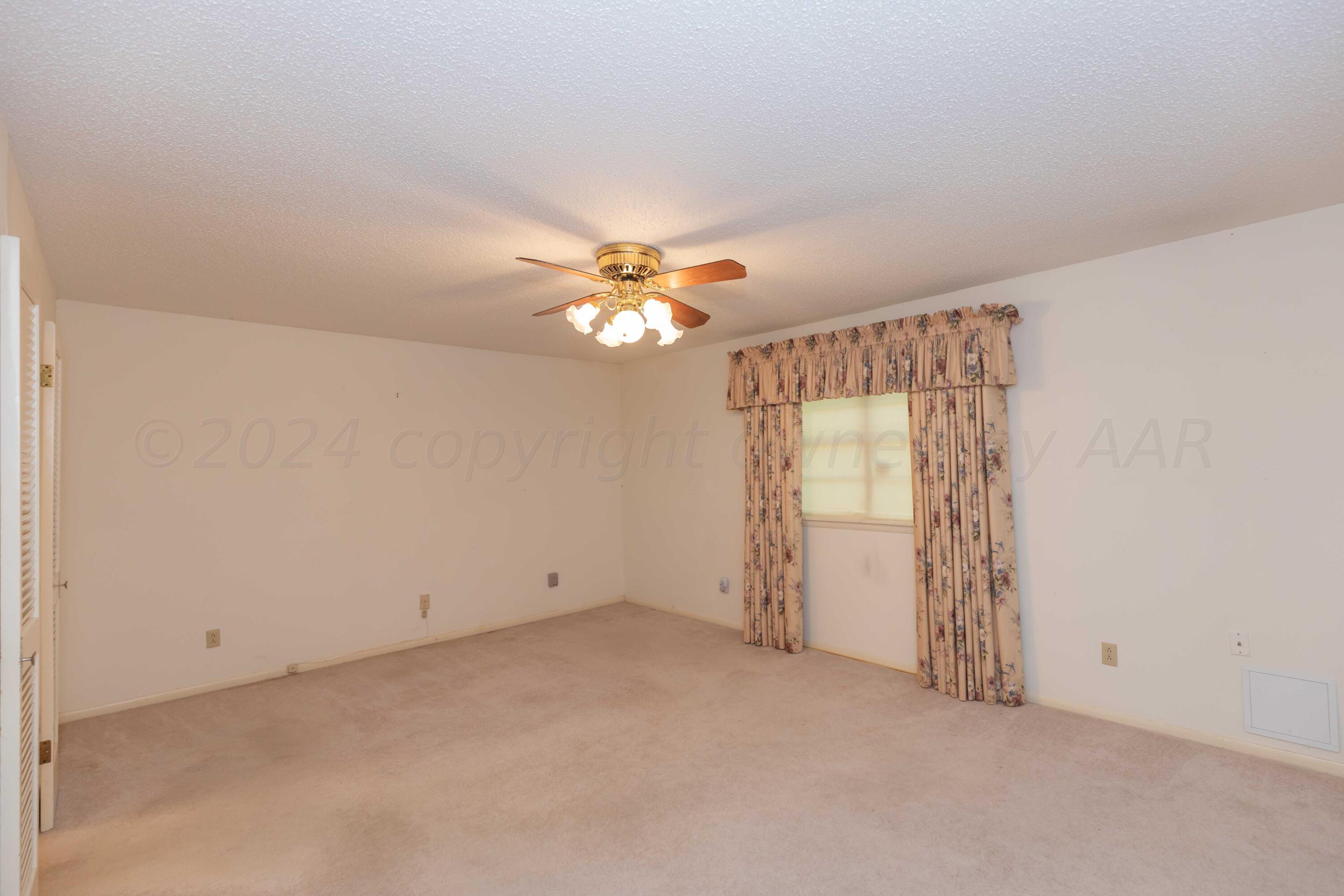 4400 Gem Lake Road Amarillo, TX 79106 - Photo 21 of 57 an empty room with windows and chandelier fan