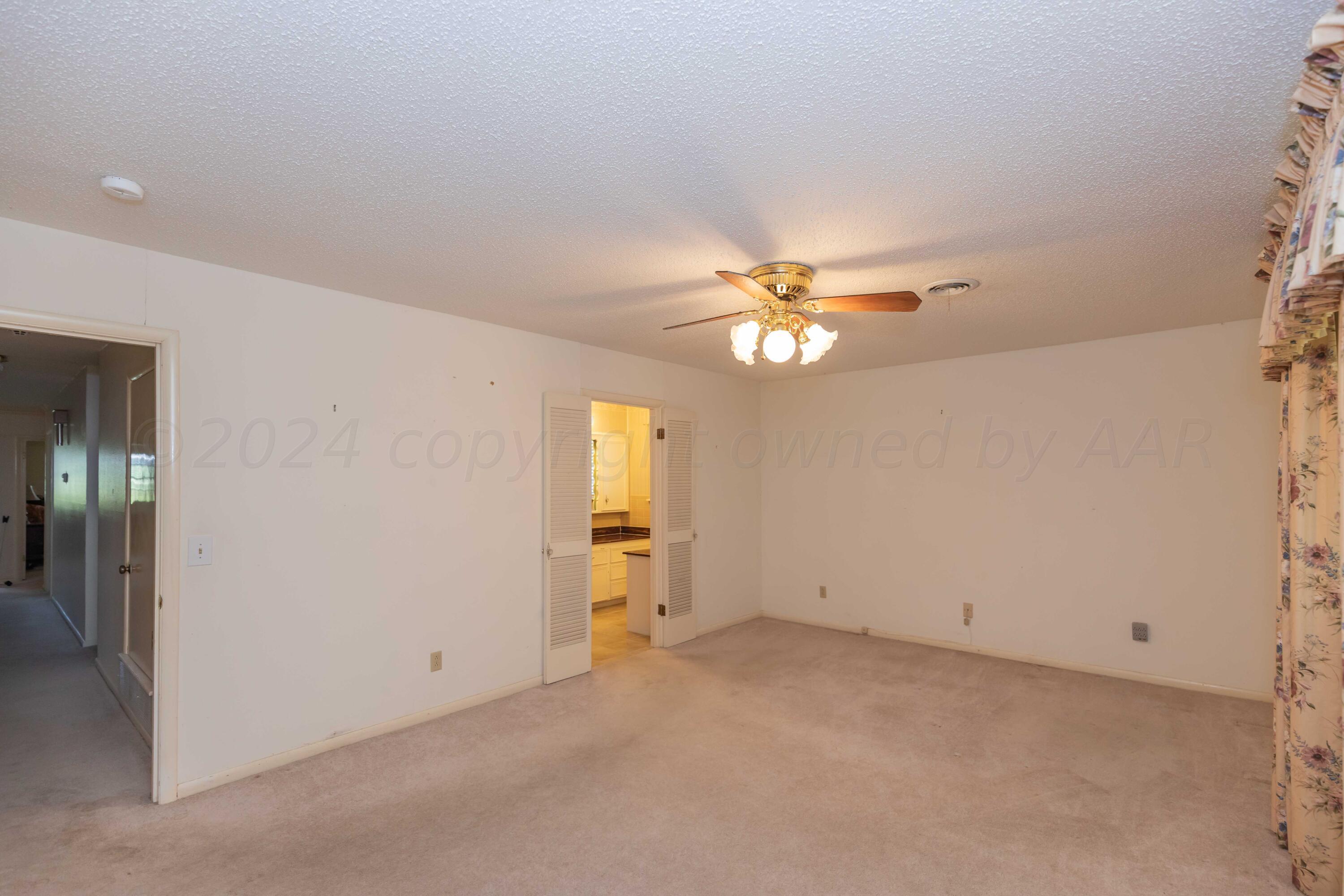 4400 Gem Lake Road Amarillo, TX 79106 - Photo 23 of 57 an empty room with a chandelier fan and a window