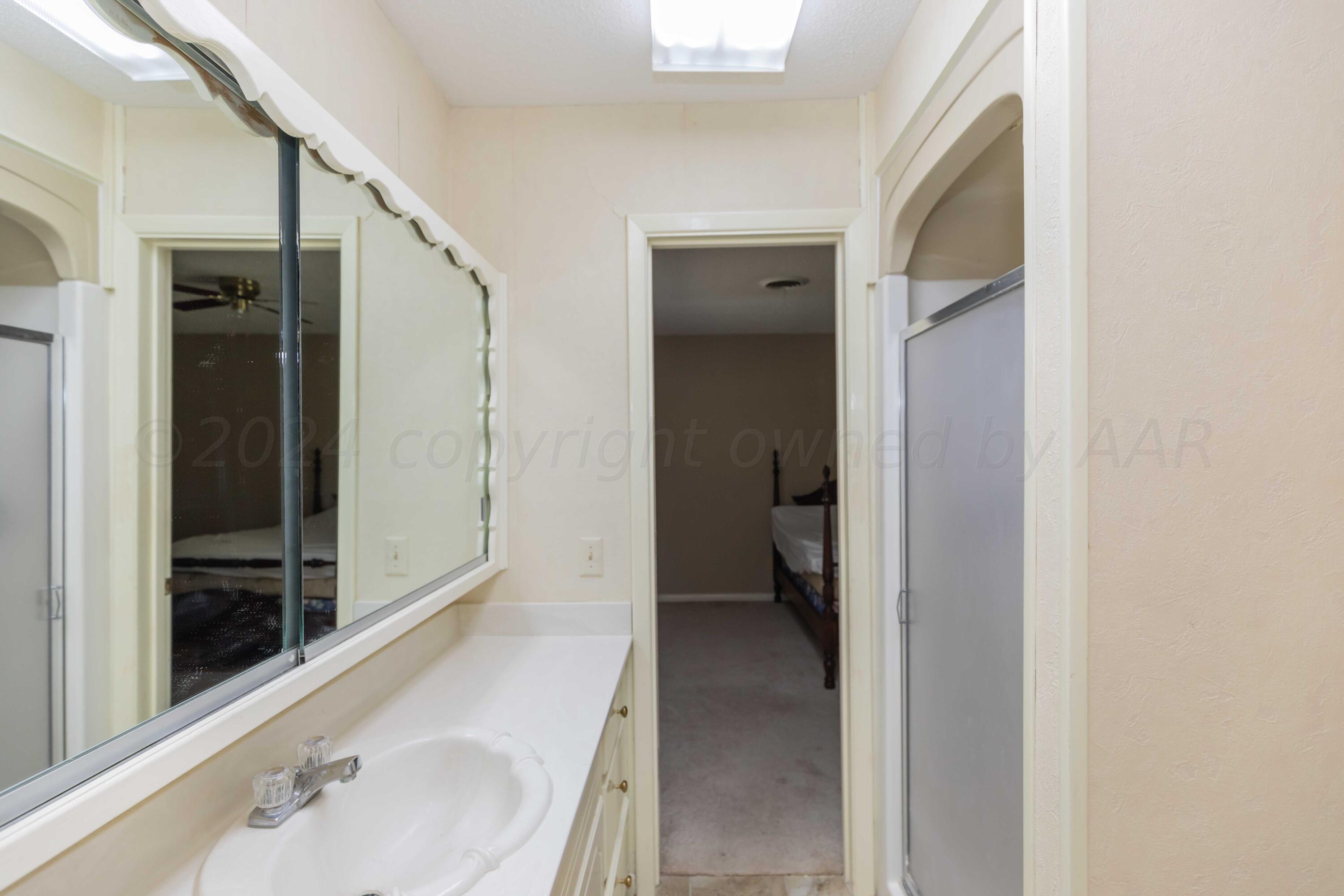 4400 Gem Lake Road Amarillo, TX 79106 - Photo 31 of 57 a en suite bathroom with a sink and a large mirror