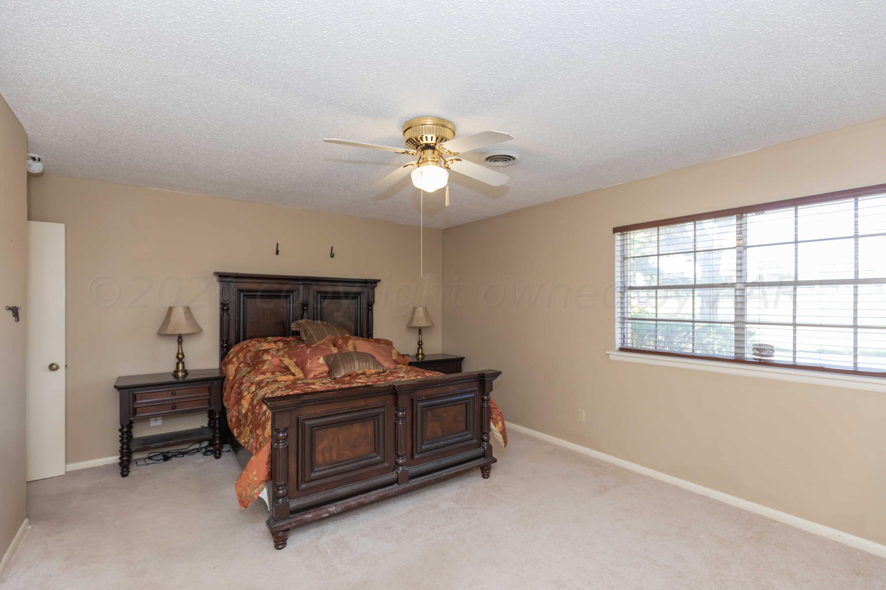 4400 Gem Lake Road Amarillo, TX 79106 - Photo 33 of 57 a bedroom with a bed and a ceiling fan in it