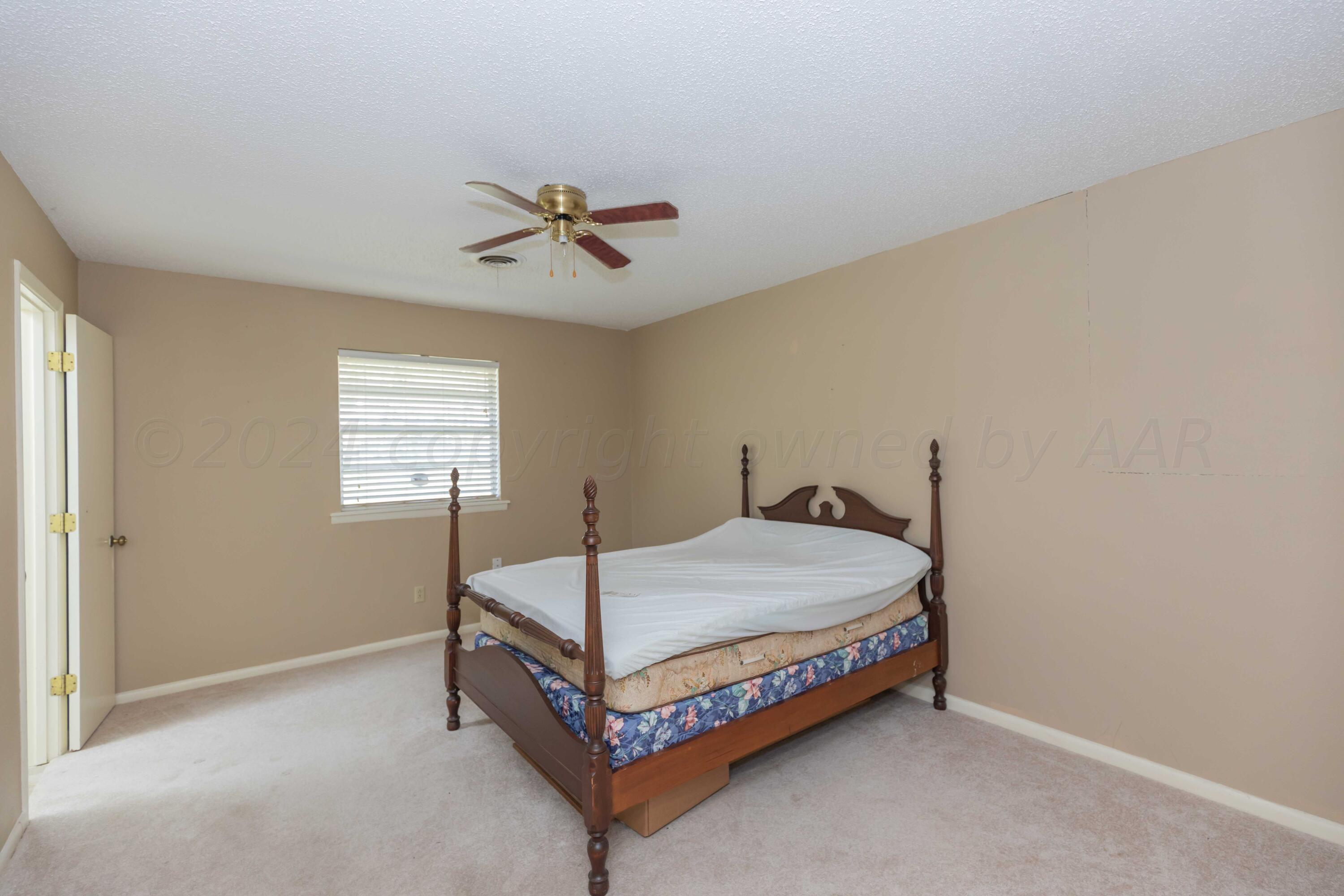 4400 Gem Lake Road Amarillo, TX 79106 - Photo 36 of 57 a bed sitting in a bedroom next to a window