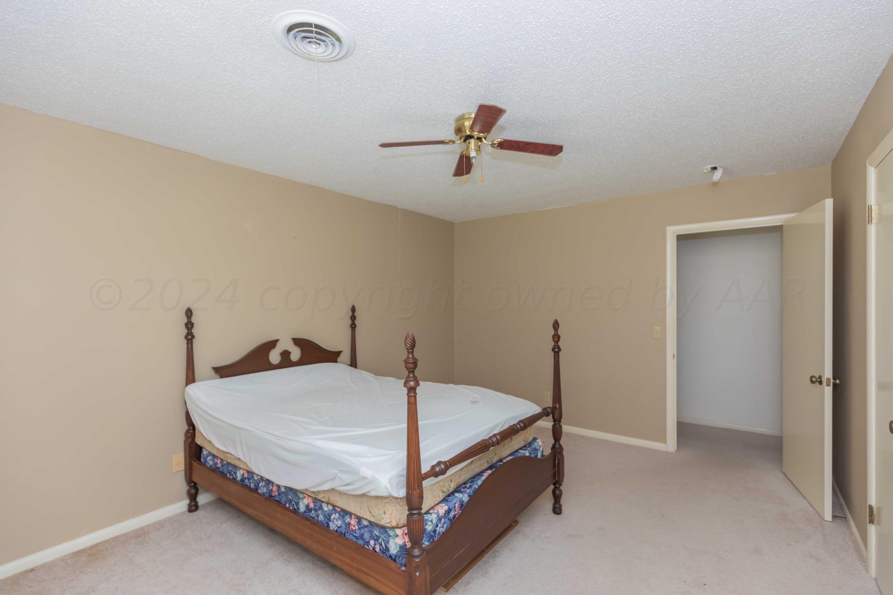 4400 Gem Lake Road Amarillo, TX 79106 - Photo 37 of 57 a bedroom with a bed and a chandelier