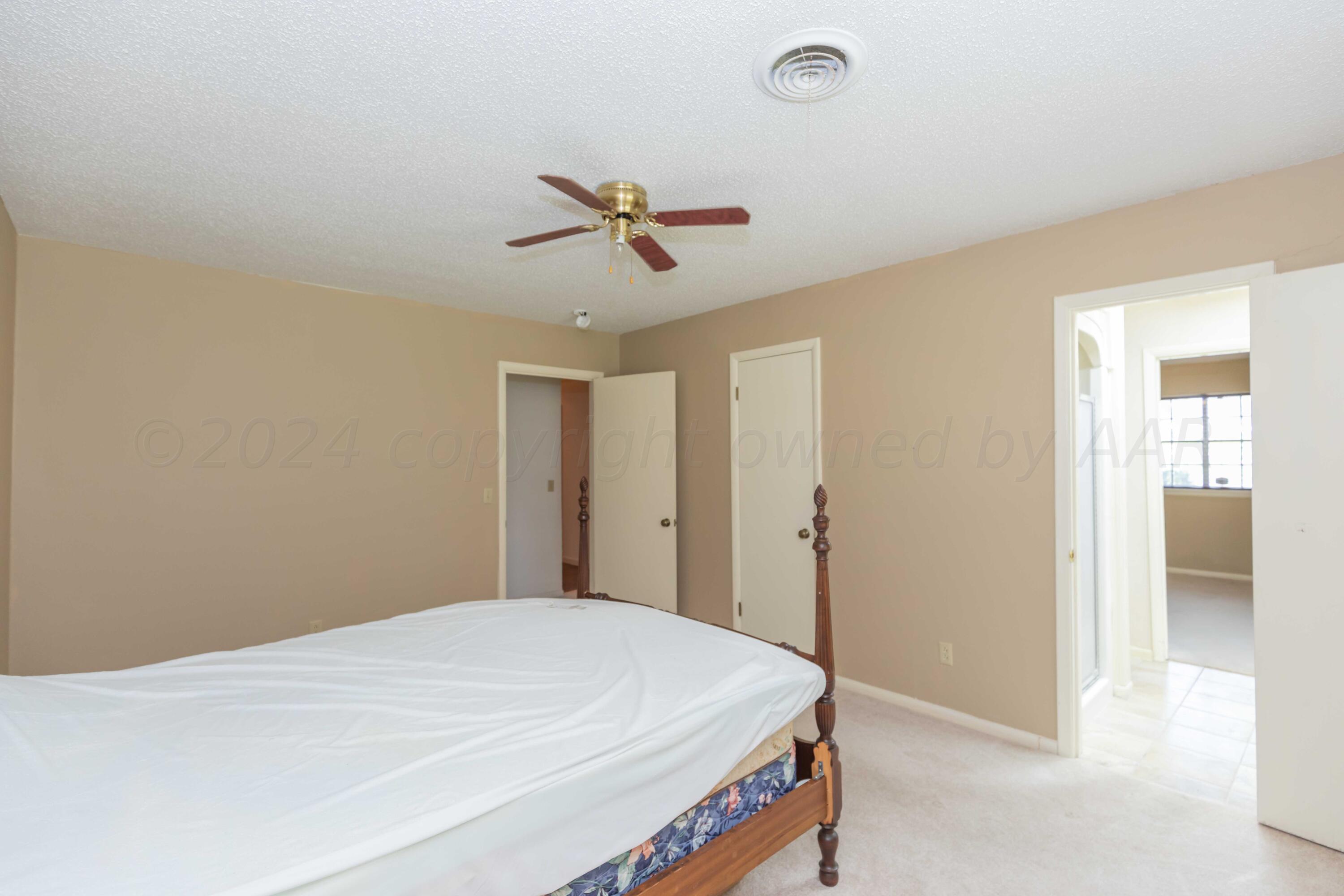 4400 Gem Lake Road Amarillo, TX 79106 - Photo 38 of 57 a bedroom with a bed and a chandelier