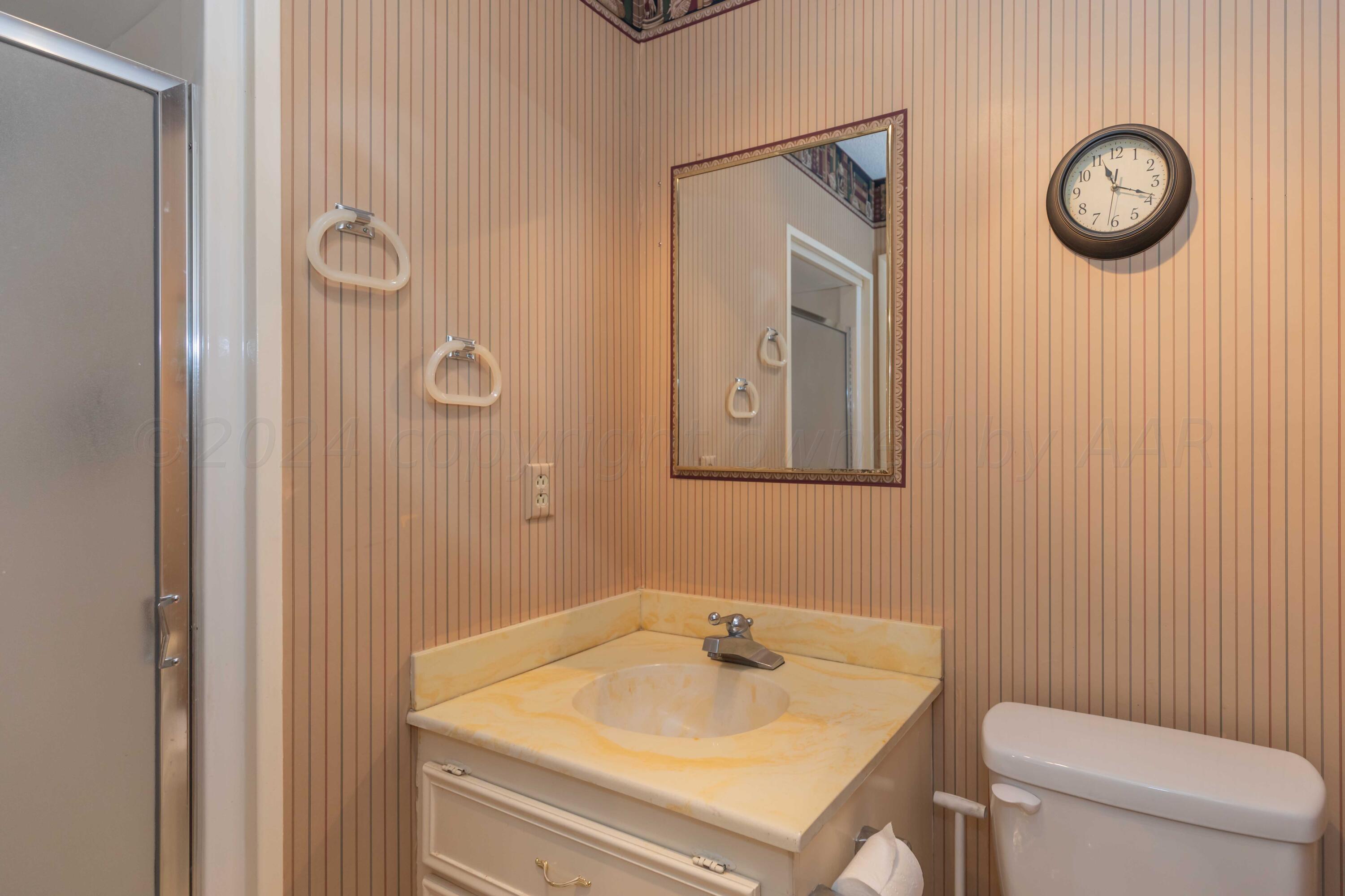 4400 Gem Lake Road Amarillo, TX 79106 - Photo 39 of 57 a bathroom with a toilet a sink and mirror