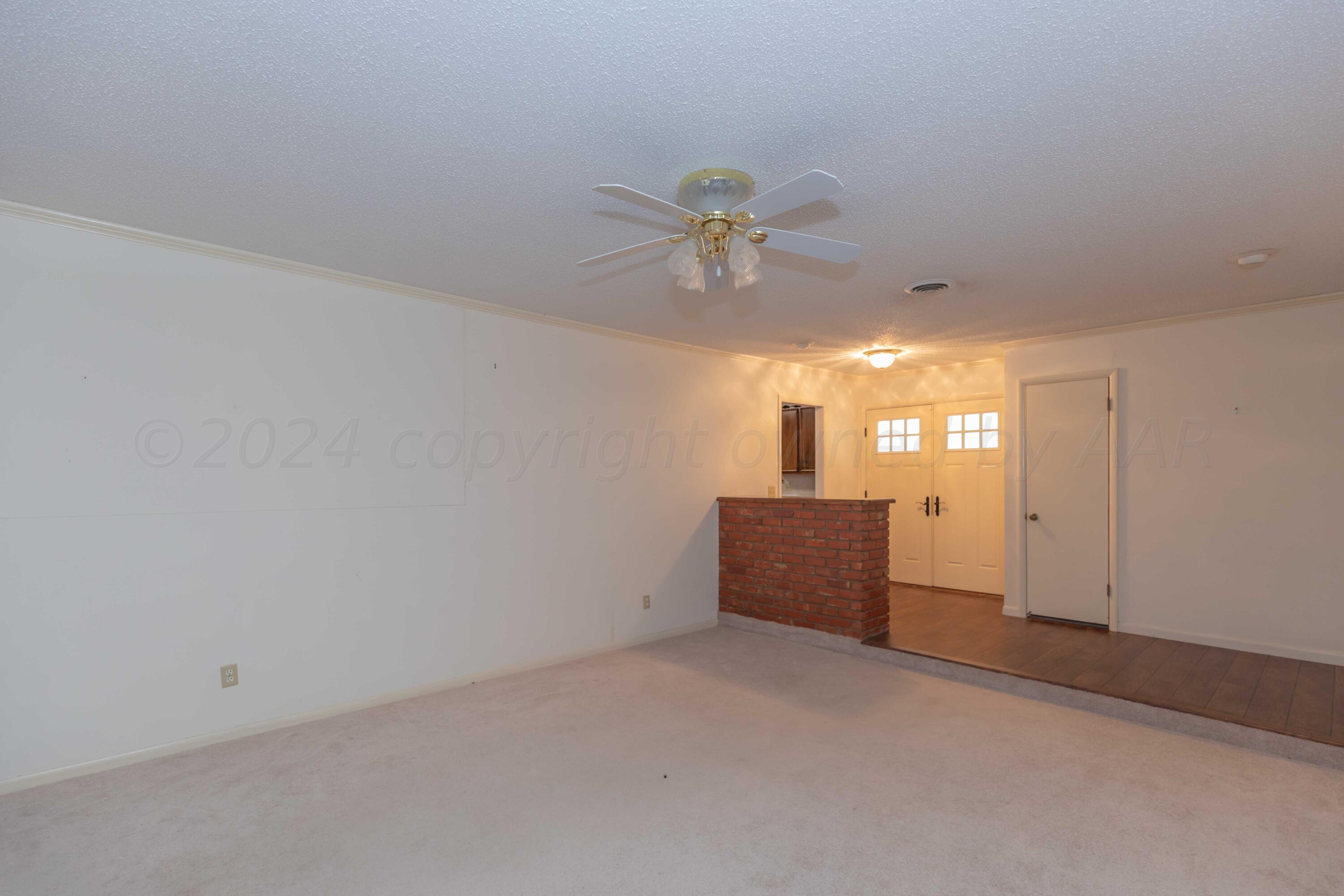 4400 Gem Lake Road Amarillo, TX 79106 - Photo 4 of 57 an empty room with chandelier fan and windows