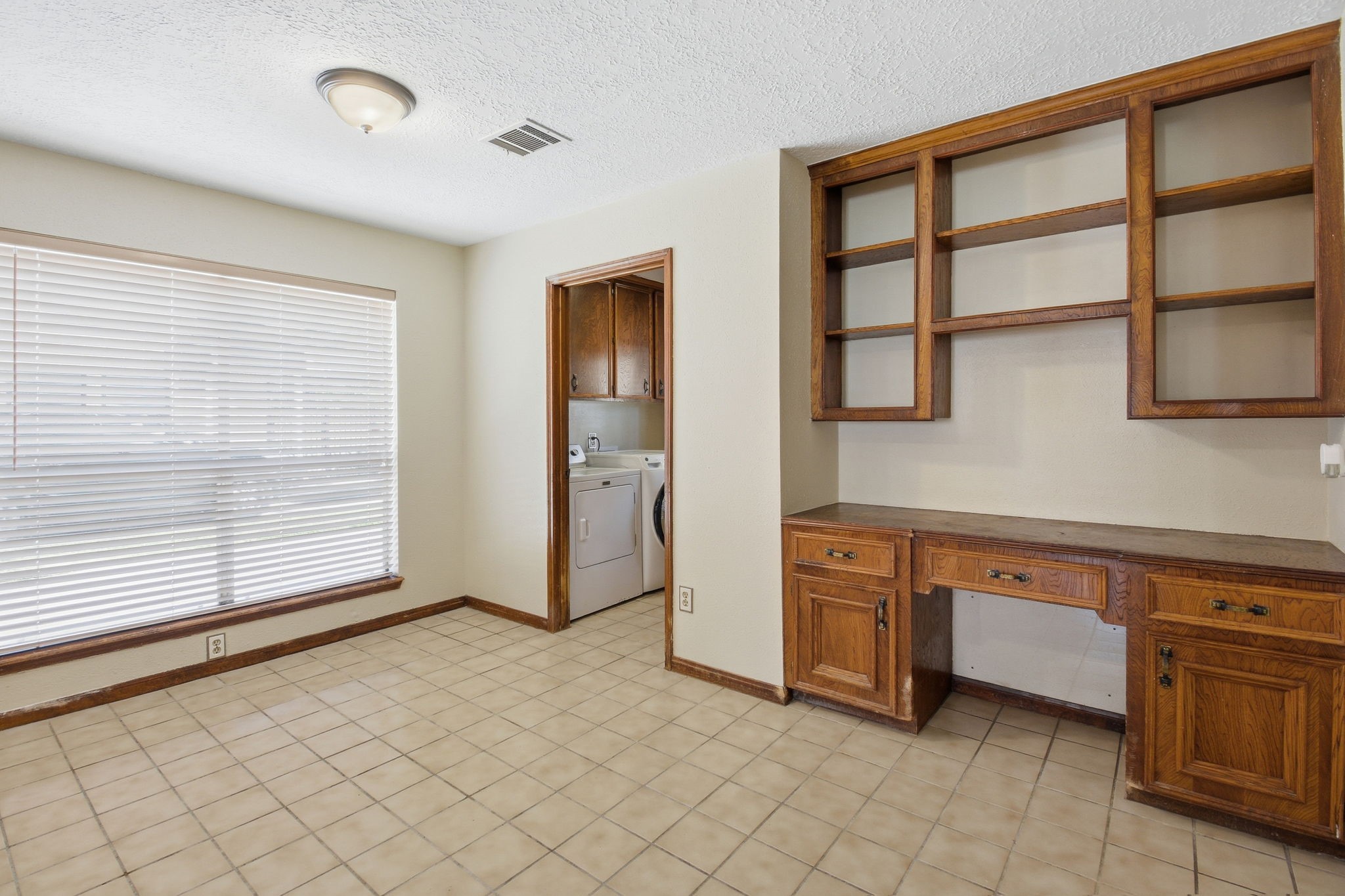 3607 El James Drive Spring, TX 77388 - Photo 14 of 50 View of the kitchen dining space and built-ins, showcasing the large window that brings in so much natural light. Laundry room on the right, as well as the entrance from the covered walkway from the garage and a half bath.