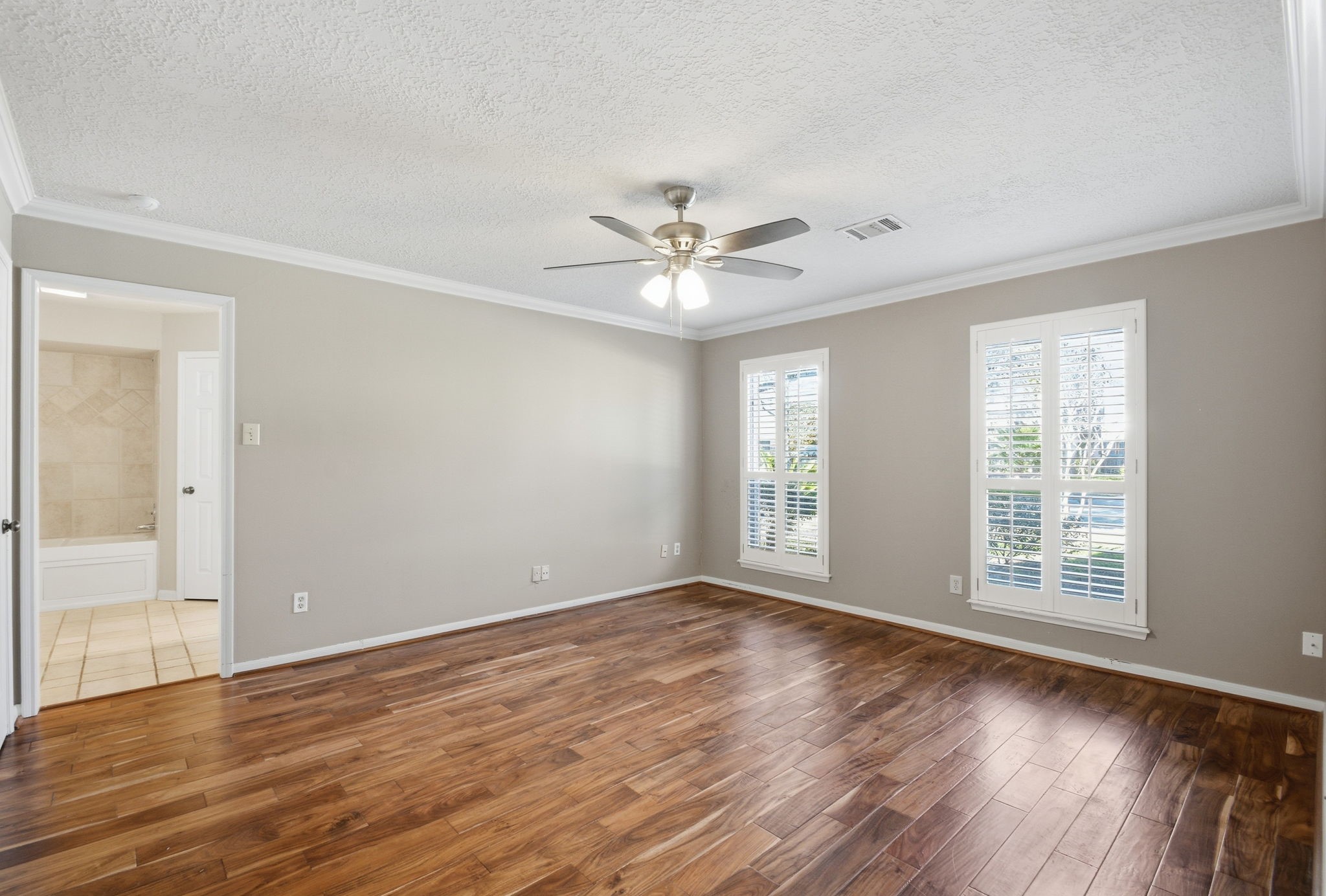 3607 El James Drive Spring, TX 77388 - Photo 20 of 50 The primary bedroom suite is located off of the foyer and has been updated with wood flooring, ceiling fan and Plantation Shutters. This bedroom is spacious enough for a king size bed with large nightstands on both sides, an armoire and a long dresser. One of the two walk-in closets is located in the bedroom.