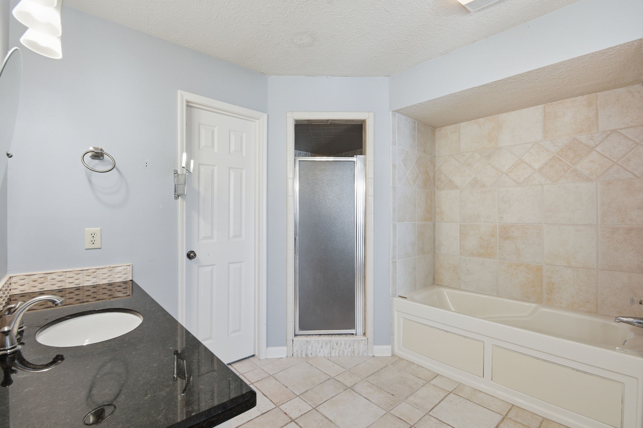 3607 El James Drive Spring, TX 77388 - Photo 24 of 50 This view of the primary bathroom shows one of the two vanities with granite countertop, the door to the private toilet space (it has a window) and the large walk-in shower.
