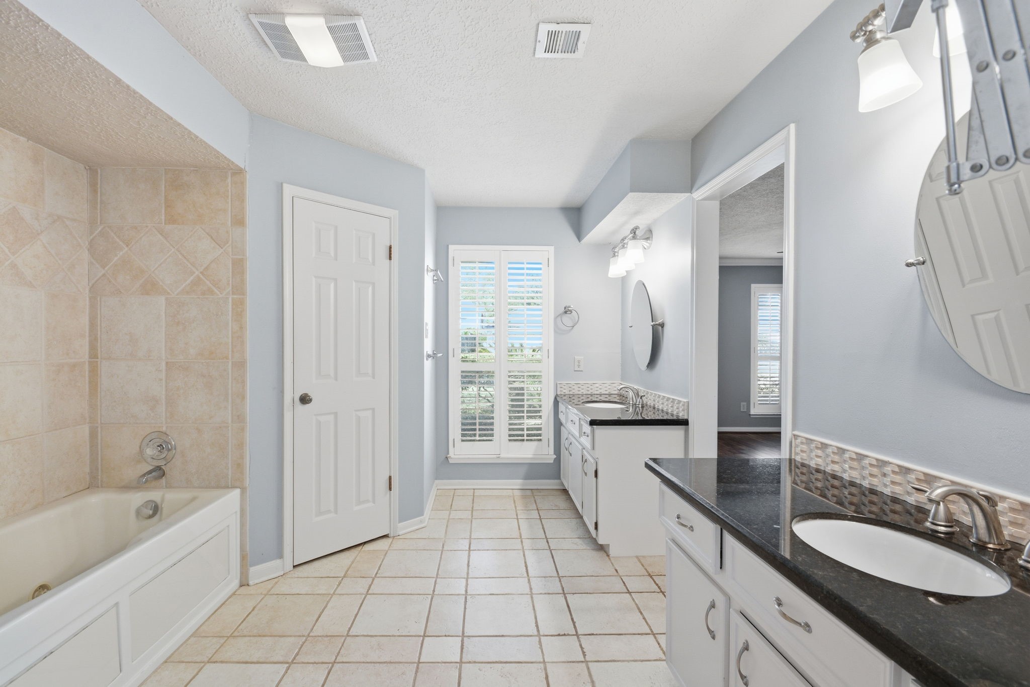 3607 El James Drive Spring, TX 77388 - Photo 25 of 50 View of the primary bath showing the floor-to-ceiling window (also with Plantation Shutters) that brings in a ton of natural light. Loving the separate vanities.
